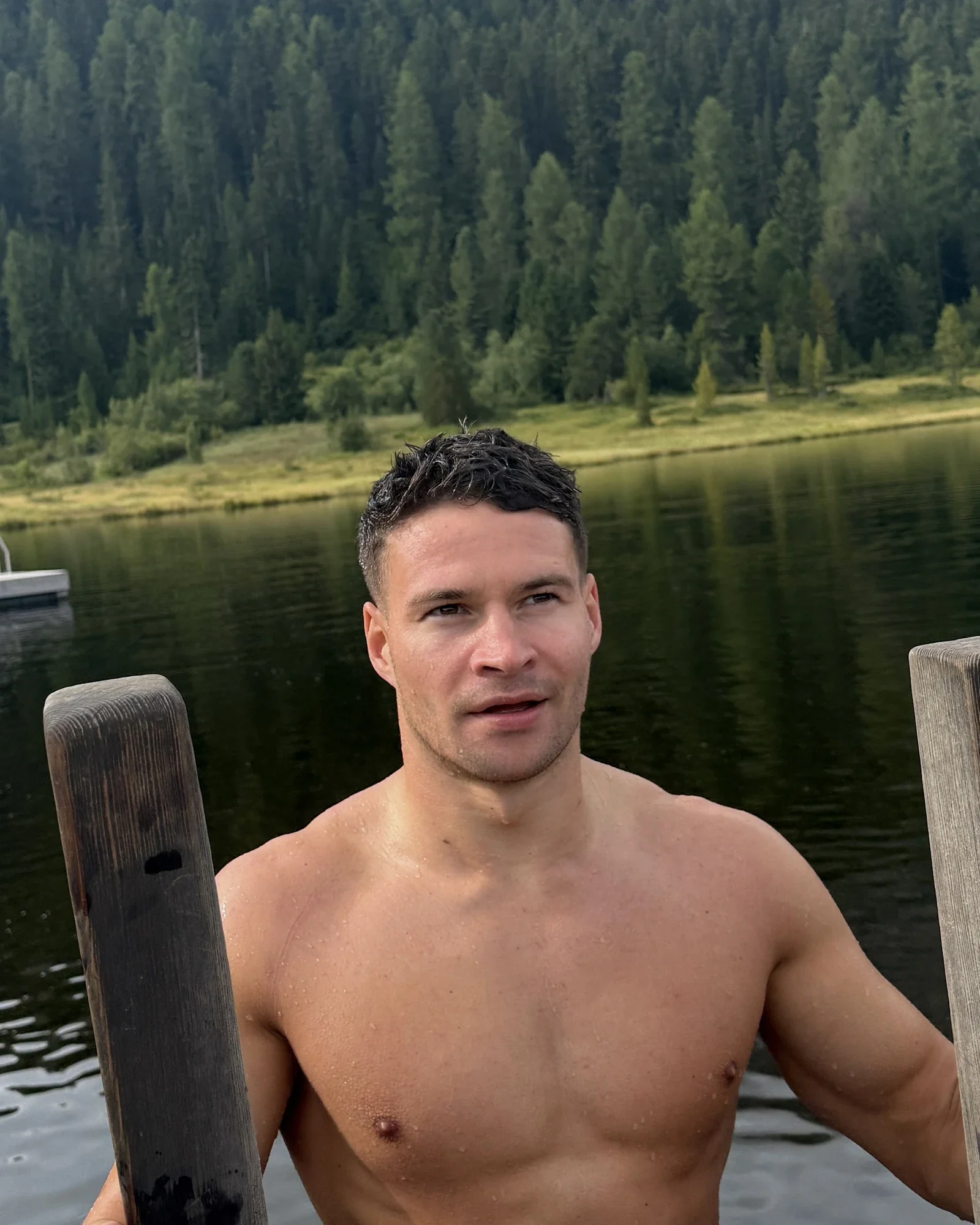 Murray Clark beside a lake surrounded by forest