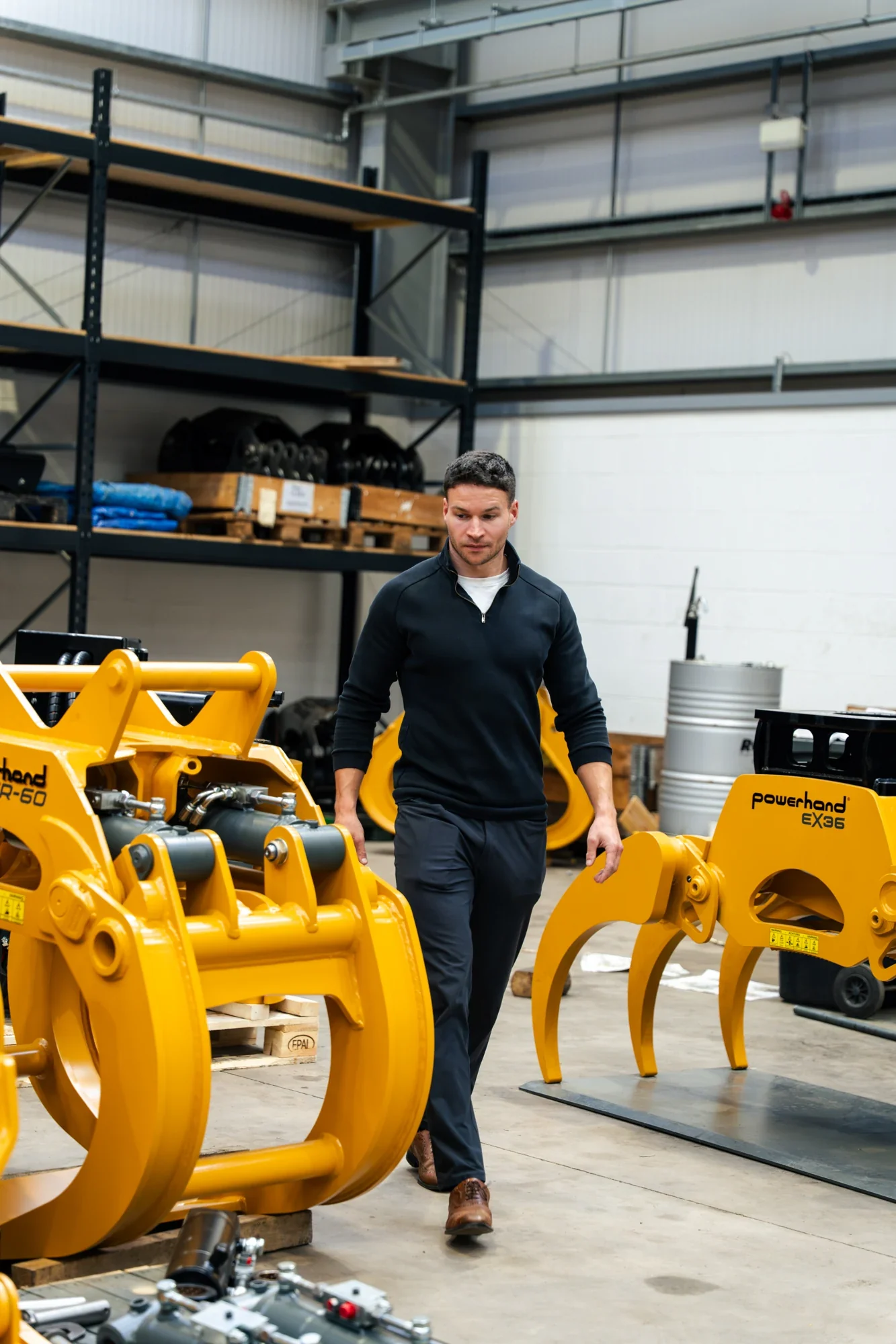 Murray Clark beside yellow Powerhand attachments in the workshop