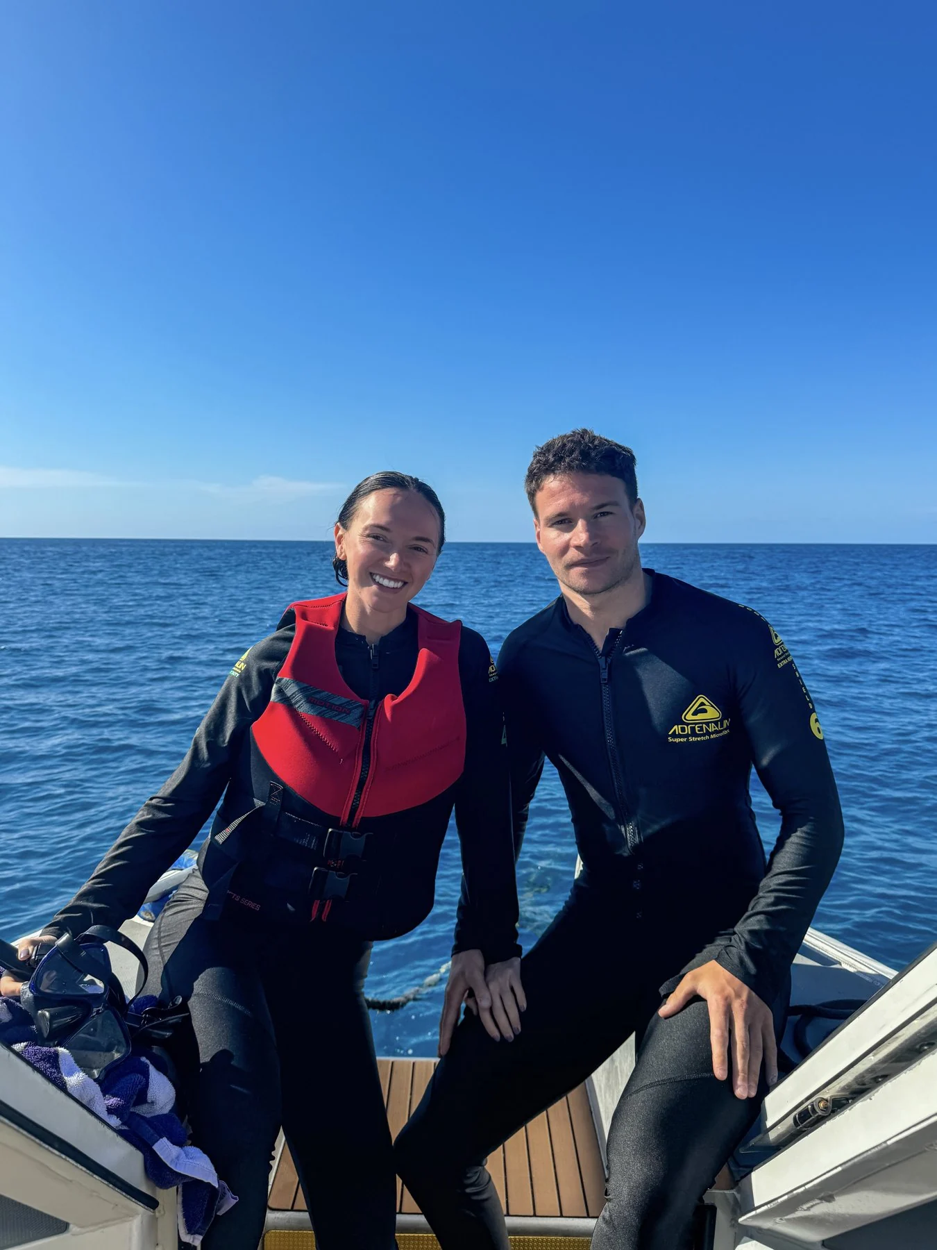 Murray Clark and Rebecca in wetsuits on a boat
