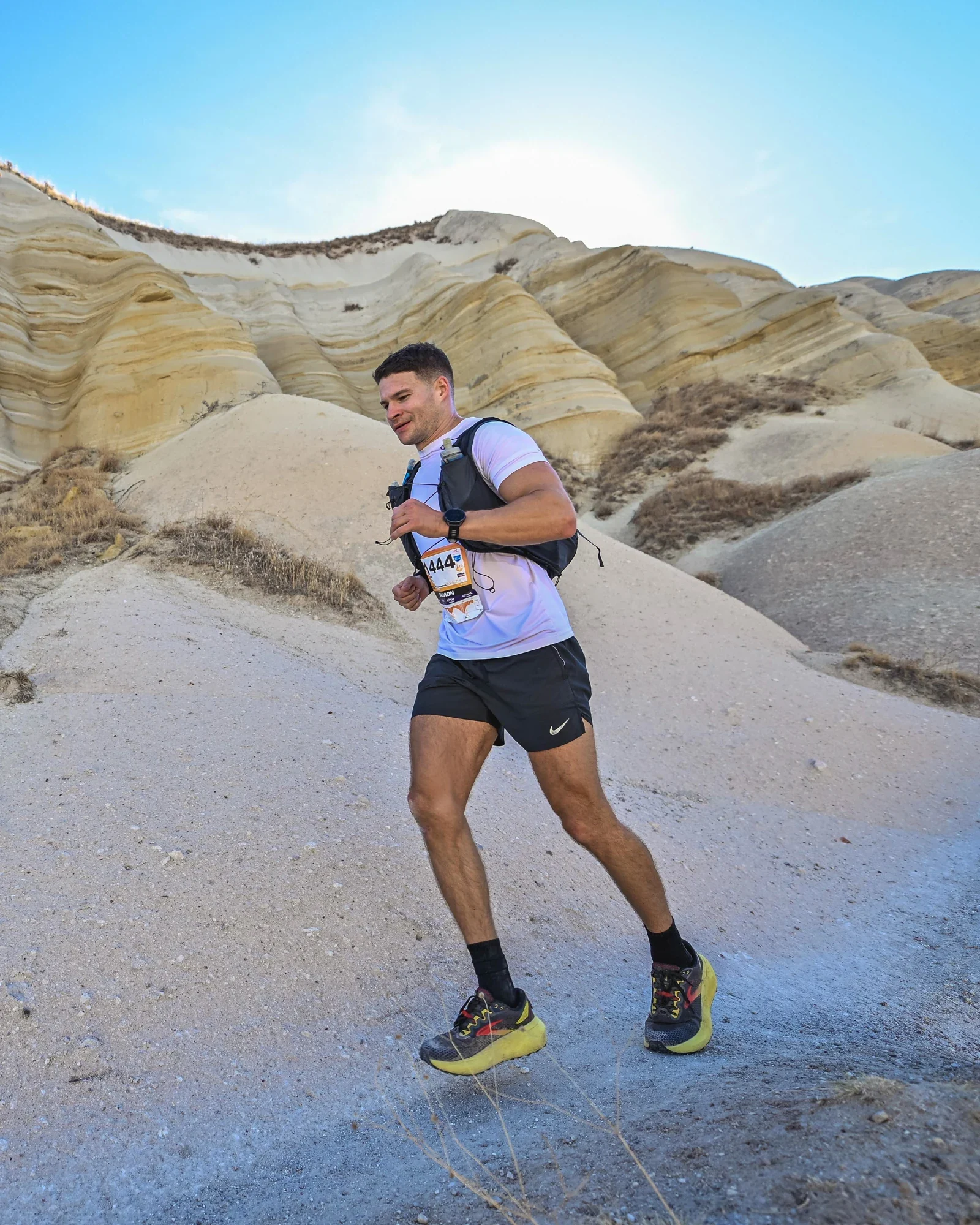 Murray Clark running along a trail through rocky hills