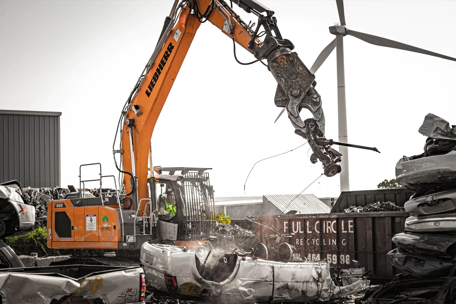 Powerhand attachment dismantling a vehicle in a recycling yard